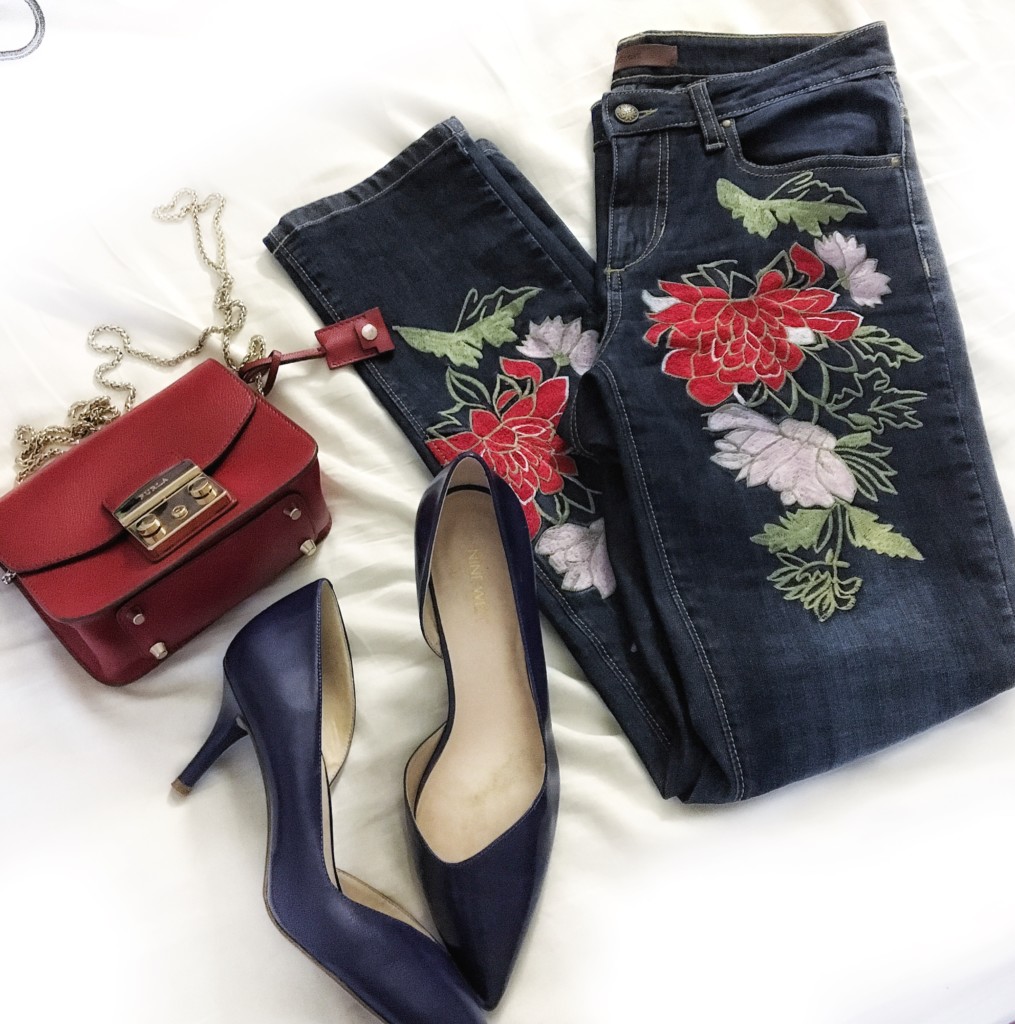 furla bag and embroidered jeans flatlay